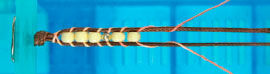 Beads being knotted to cord